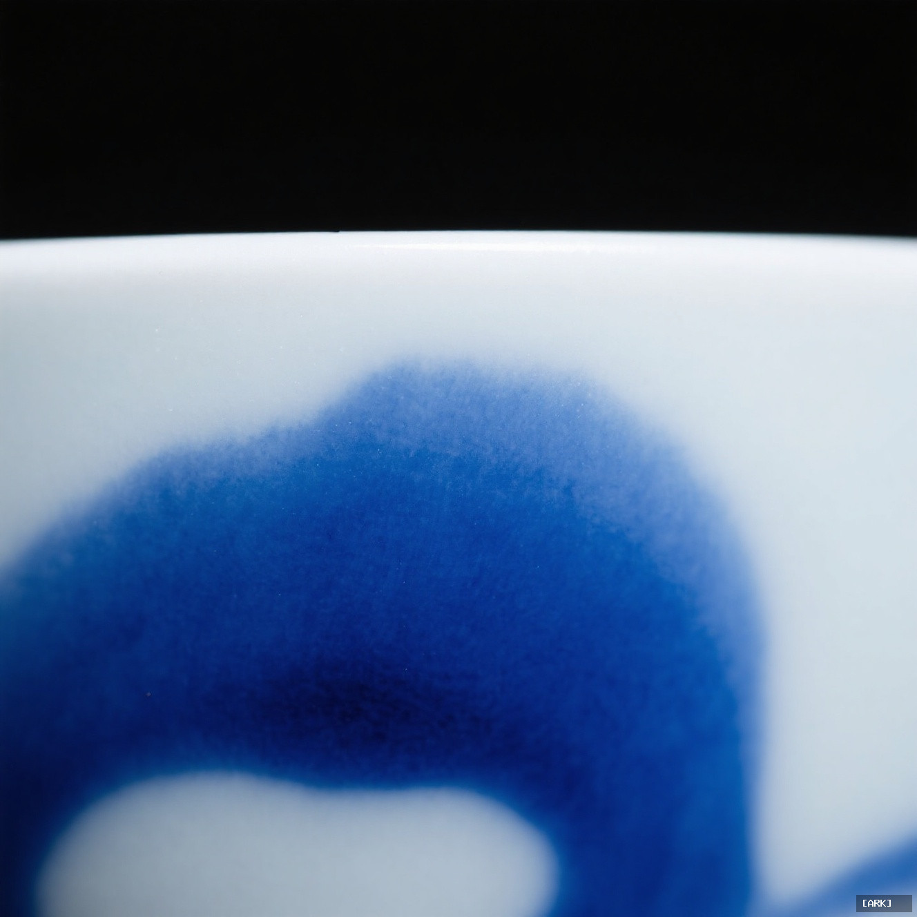 macro close-up of cobalt blue bleeding into white porcelain body under glaze…, featuring blue and white porcelain u…